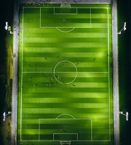 bird's-eye view photography of green soccer field with lights